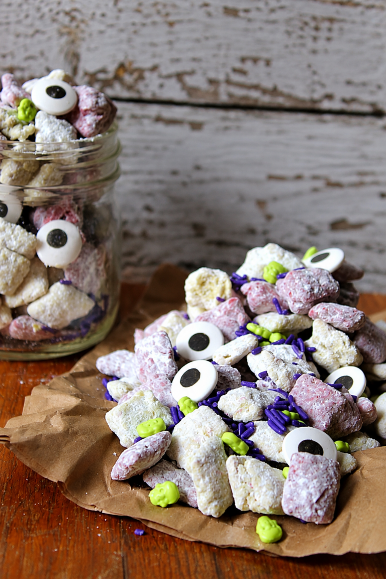 Monster Mash Munch Halloween snack mix with colorful cereal pieces, candy eyes, purple sprinkles, and green candies.