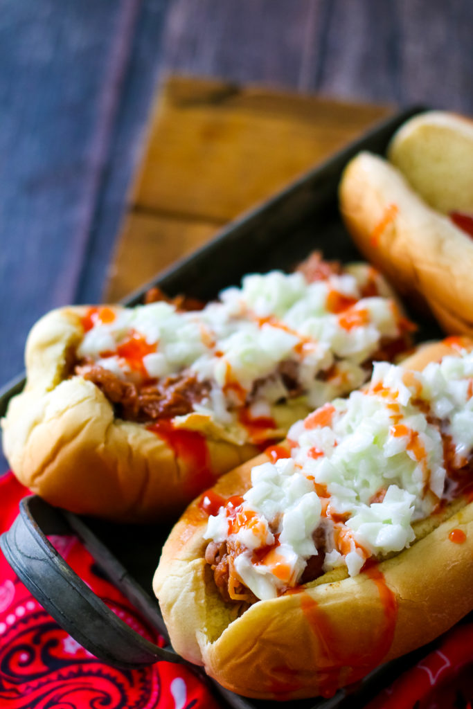 Pulled Pork Spicy Slaw Dogs are going to be your new favorite dish this summer!! Comes together super quick. Perfect easy dinner!
