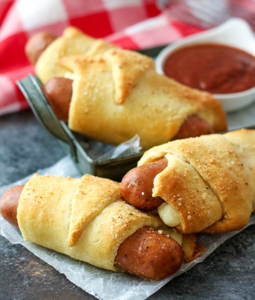 Cheesy Italian Pigs in a blanket with mozzarella wrapped in flaky dough are perfect for dipping in marinara and make a quick weeknight dinner!