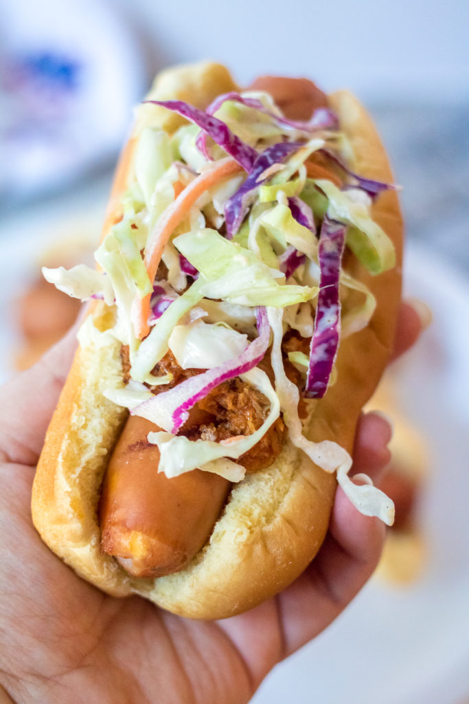 Slaw Dogs are going to be your new favorite summer dinner! Grilled hot dogs topped with pulled pork and crisp coleslaw, the perfect combination!