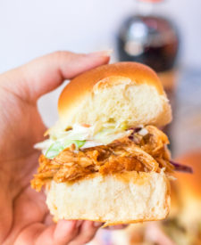Slow Cooker Root Beer BBQ Sliders are the perfect dinner for summer! Flavorful slow cooked chicken piled on soft slider buns with a scoop of coleslaw, yum!