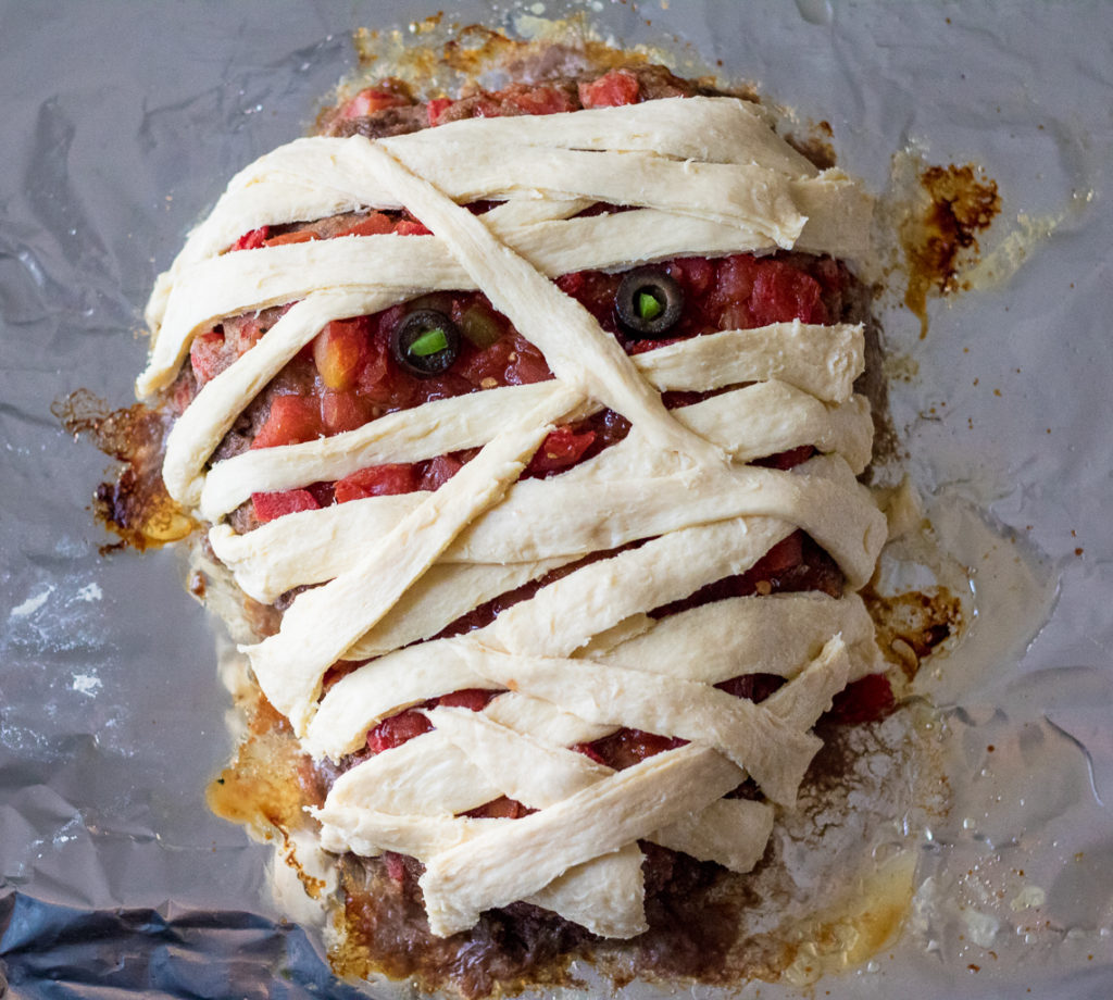 Mummy Meatloaf is a spooky and delicious Halloween dinner your little ghouls and goblins will love! Flavorful meatloaf wrapped in crescent mummy strips yum!