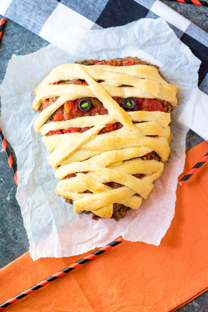 Mummy Meatloaf is a spooky and delicious Halloween dinner your little ghouls and goblins will love! Flavorful meatloaf wrapped in crescent mummy strips yum!