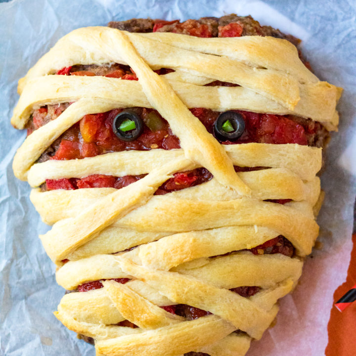 Mummy Meatloaf is a spooky and delicious Halloween dinner your little ghouls and goblins will love! Flavorful meatloaf wrapped in crescent mummy strips yum!
