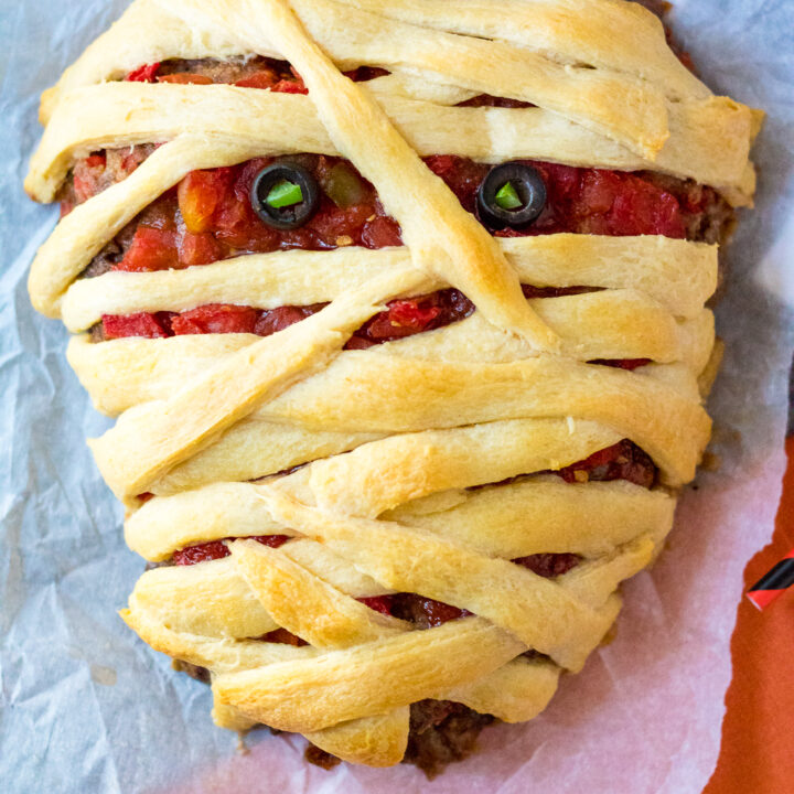 Mummy Meatloaf is a spooky and delicious Halloween dinner your little ghouls and goblins will love! Flavorful meatloaf wrapped in crescent mummy strips yum!