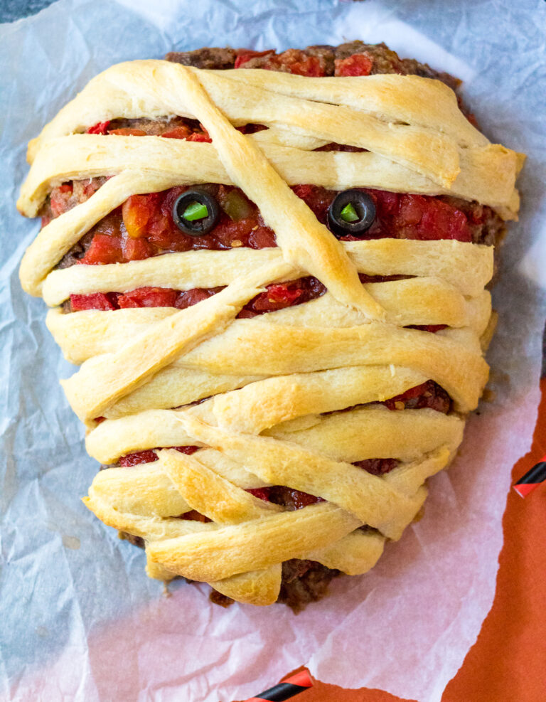 Mummy Meatloaf is a spooky and delicious Halloween dinner your little ghouls and goblins will love! Flavorful meatloaf wrapped in crescent mummy strips yum!