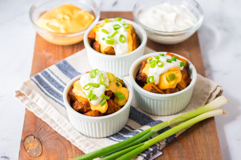 Seasoned potatoes get nice and crispy before getting topped with nacho cheese, sour cream and green onions, yum!