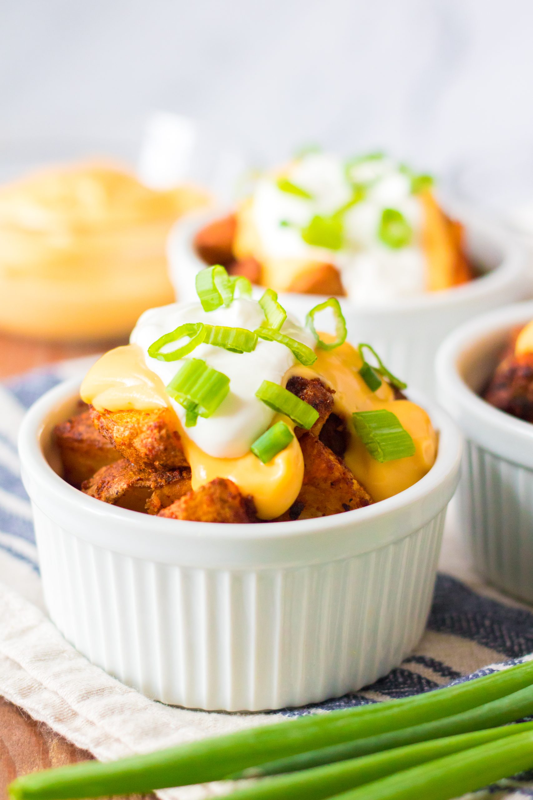 Seasoned potatoes get nice and crispy before getting topped with nacho cheese, sour cream and green onions, yum!
