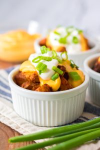 Seasoned potatoes get nice and crispy before getting topped with nacho cheese, sour cream and green onions, yum!
