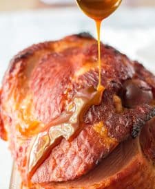 The sweet glazed is drizzled over the ham.