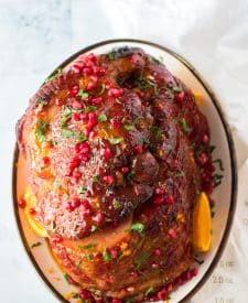 Orange juice, brown sugar, honey and cinnamon make up a deliciousOrange zest, pomegranate seeds and parsley give this ham it’s festive colors.