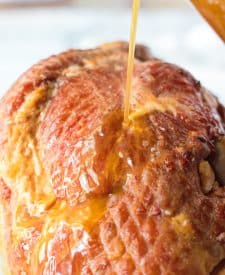 The sweet glaze is drizzled all over the ham.