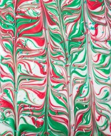 White, red and green melted chocolate swirled
