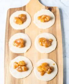 Apple filling spooned into the middle of the dough rounds