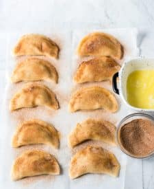 Filled empanadas brushed with butter and cinnamon sugar