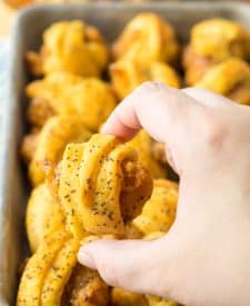 Glazed Chicken Bite in hand with pan of them in the background