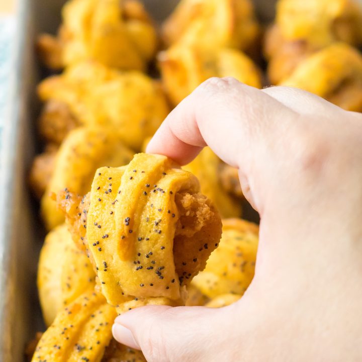 Glazed Chicken Bite in hand with pan of them in the background