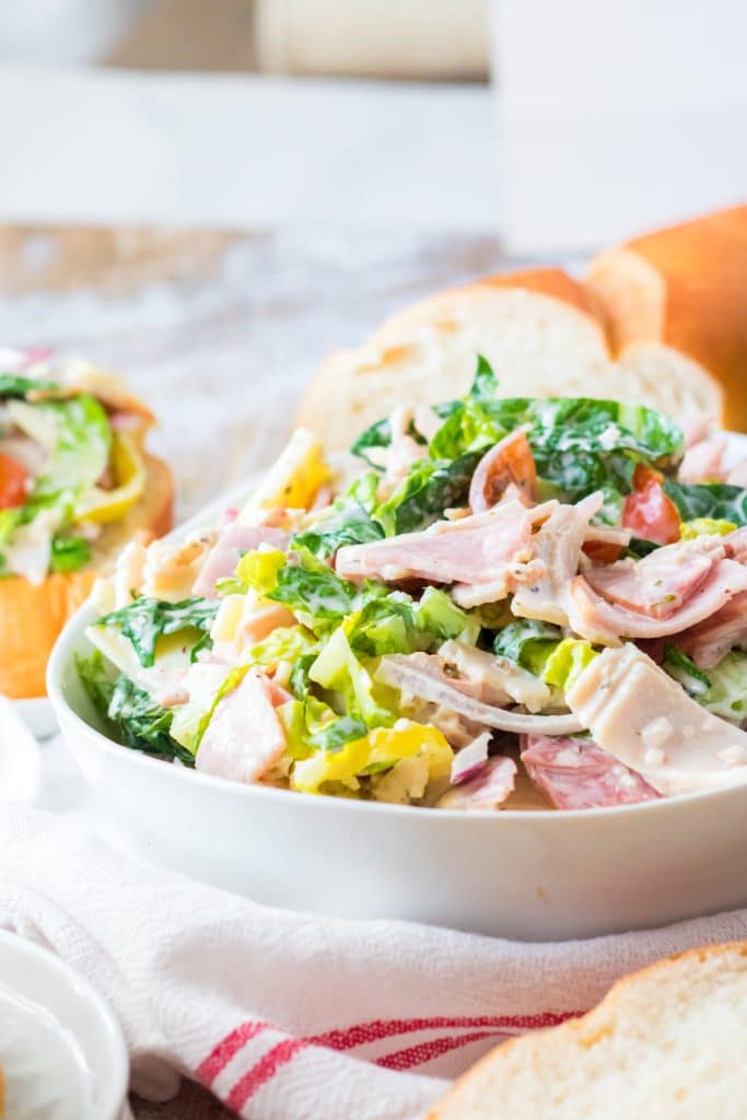 Side shot of hoagie dip piled high in a white bowl.