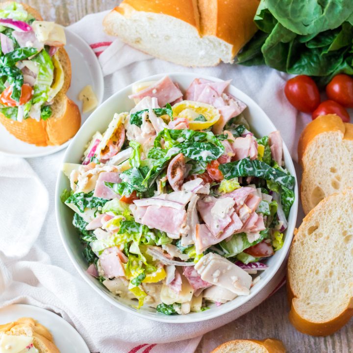 Hoagie Dip piled in a white bowl with bread around it.
