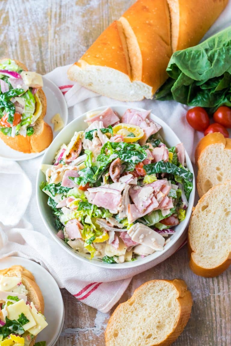 Hoagie Dip piled in a white bowl with bread around it.