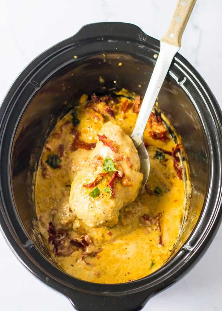 Slow Cooker Marry Me Chicken in the slow cooker being spooned out