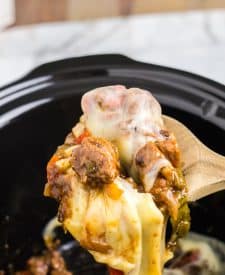 Slow Cooker Philly Cheesesteak Bites in slow cooker in spoon with melted cheese pull