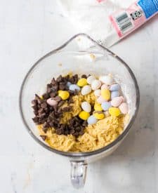 Easter Cookie Cake dough in bowl with chocolate chips and cadbury eggs