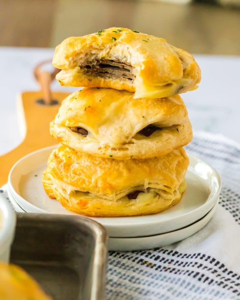 French Dip Biscuits stacked with a bite taken out of one.