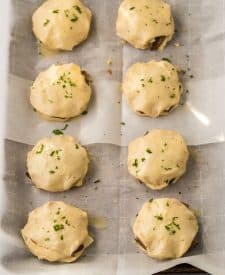 French Dip Biscuits closed up on sheet pan brushed with butter and parsley