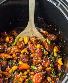 Slow Cooker Cashew Chicken in a slow cooker being spooned out
