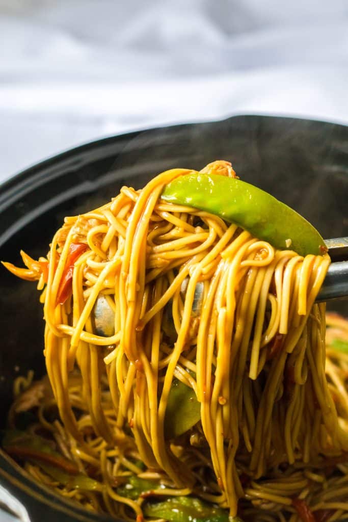 Slow Cooker Chicken Lo Mein with noodles in slow cooker being lifted out