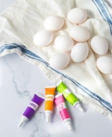 Ingredient shot of Brightly colored Slow Cooker Dyed Easter Eggs in a basket, egg s and food coloring