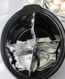 Slow Cooker Dyed Easter Eggs slow cooker shot with aluminum foil dividing the slow cooker into 4 sections