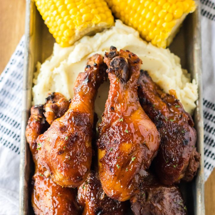 Slow Cooker Honey BBQ Drumsticks piled high with mashed potatoes and corn on the cob