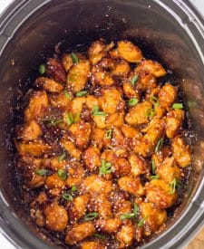 Slow Cooker Orange Chicken in slow cooker cooked with sesame seeds and scallions