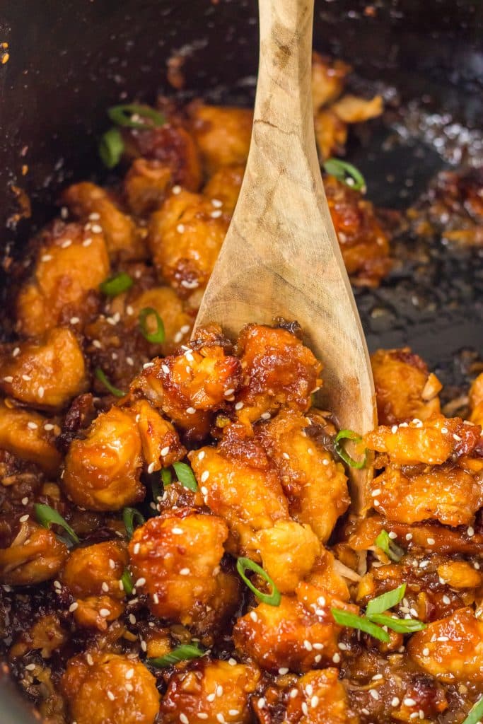 Slow Cooker Orange Chicken in the slow cooker with a spoon