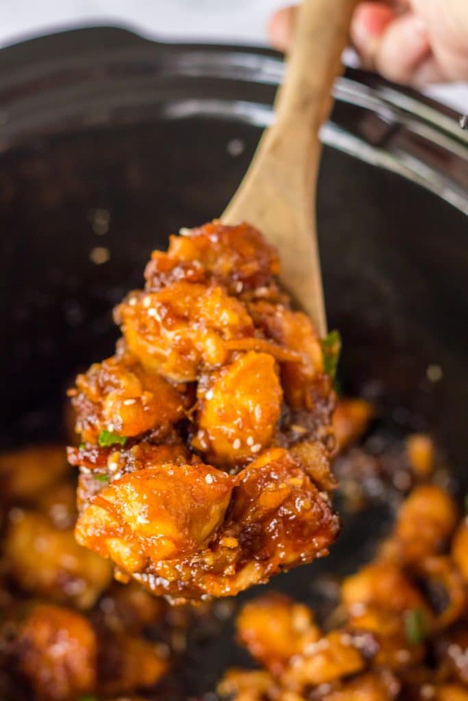 Slow Cooker Orange Chicken being spooned out of the slow cooker