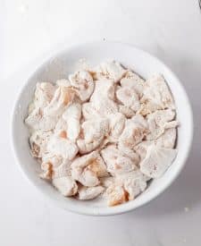 Slow Cooker Orange Chicken in cornstarch in a bowl