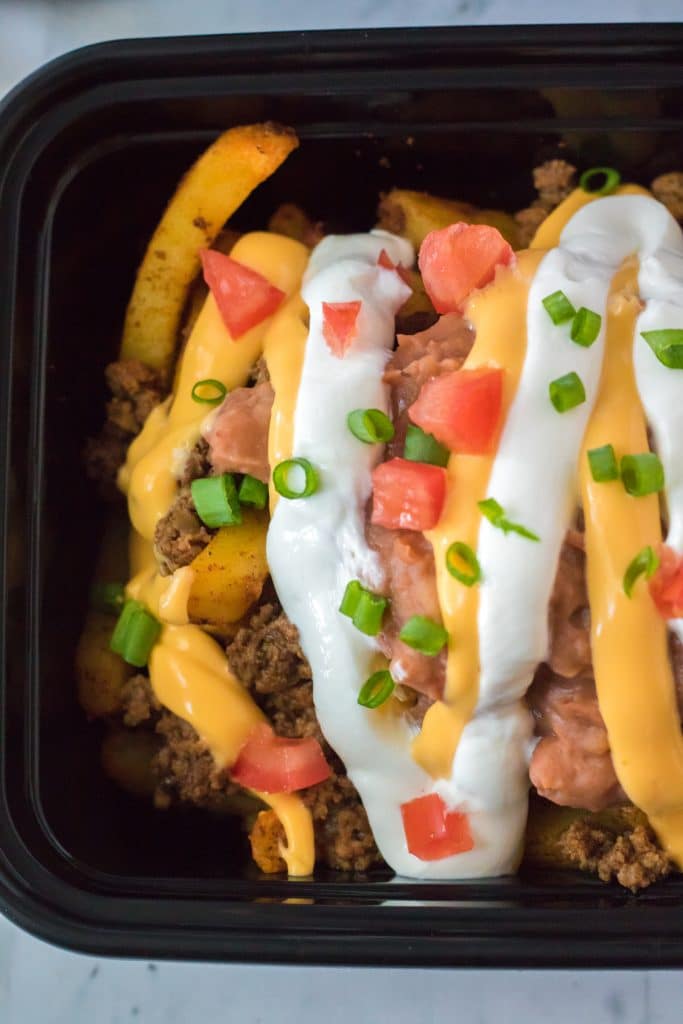 Copycat Taco Bell Nacho Supreme Fries close up with nacho cheese and sour cream