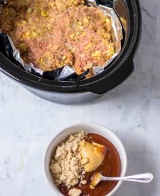 Slow Cooker Easy Meatloaf uncooked in the slow cooker with the sauce ingredients in a bowl