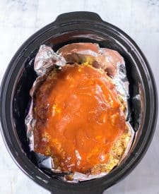 Slow Cooker Easy Meatloaf uncooked in the slow cooker with sauce on top