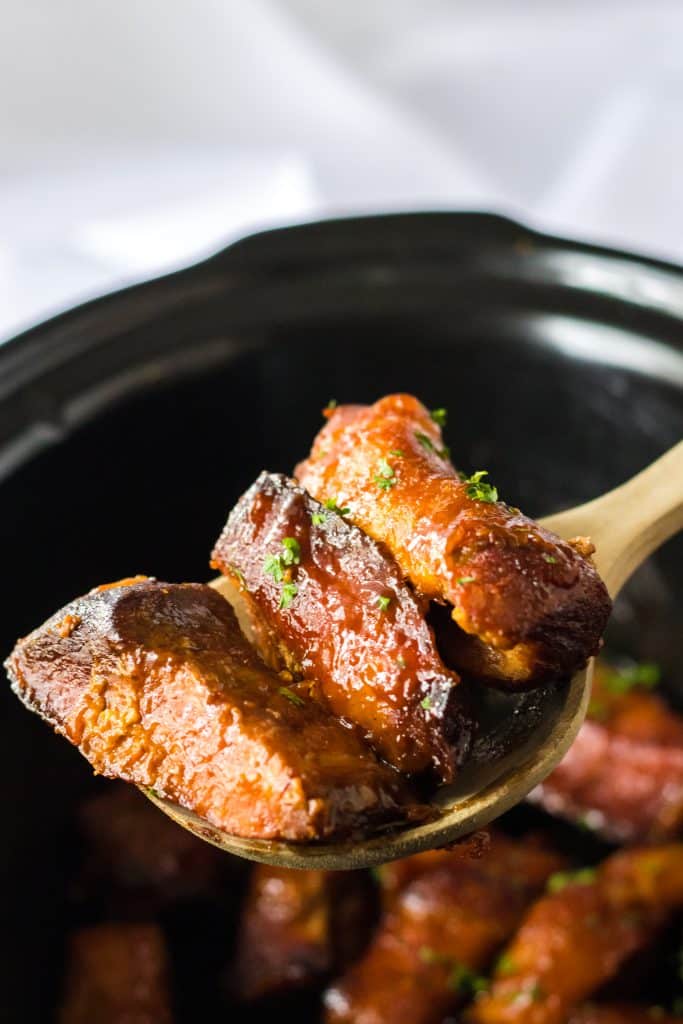 Slow Cooker Honey Peach Country Ribs being spooned out of slow cooker
