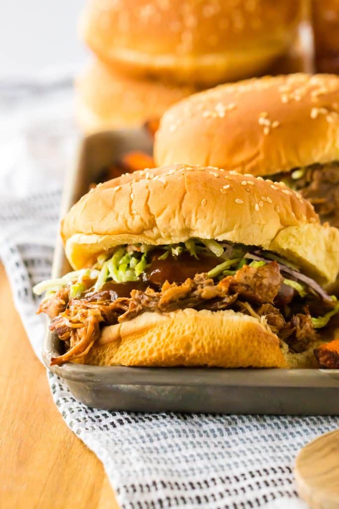 Slow Cooker Root Beer Pulled Pork piled on a bun with coleslaw
