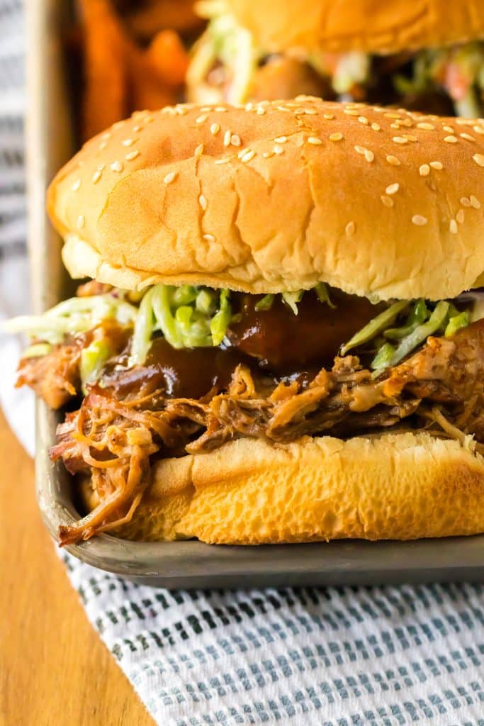 Slow Cooker Root Beer Pulled Pork piled on a bun with coleslaw