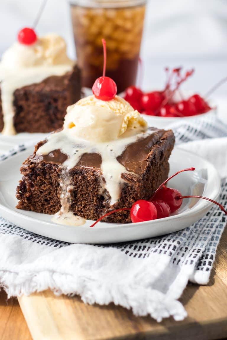 Copycat Cracker Barrel Double Fudge Coca Cola Cake plated with ice cream and cherry