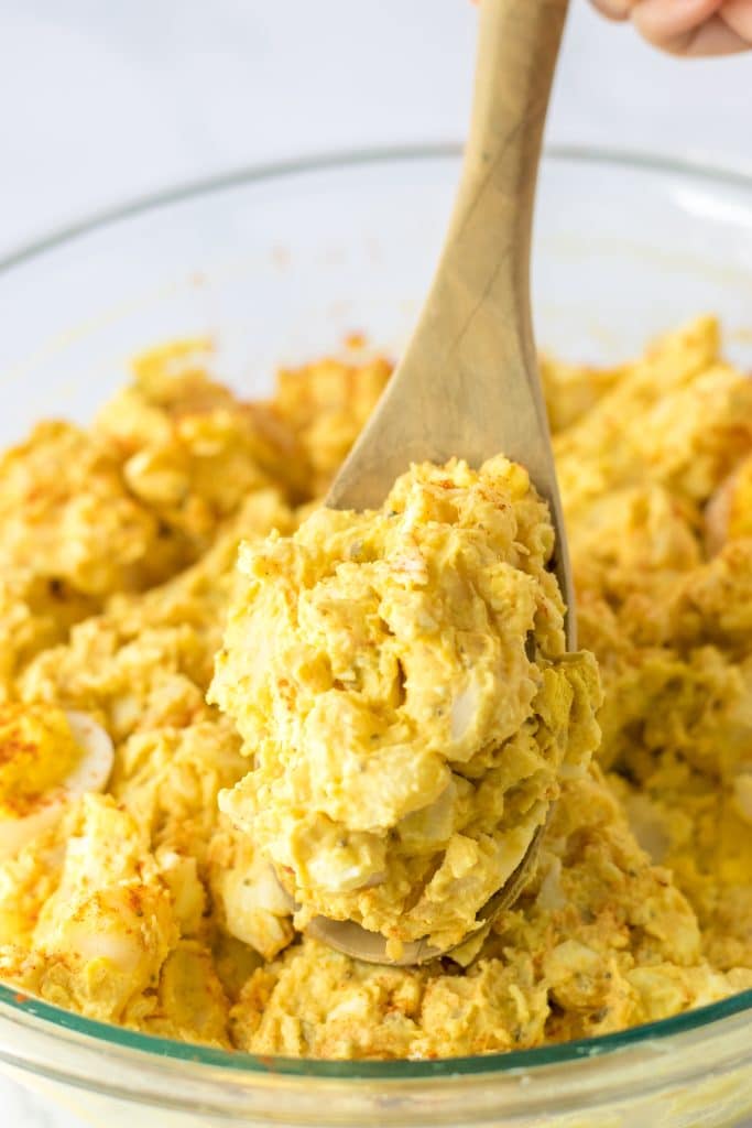Deviled Egg Potato Salad in a bowl being spooned out
