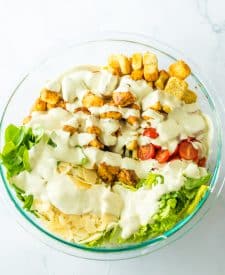 Chicken Caesar Pasta Salad in bowl with dressing