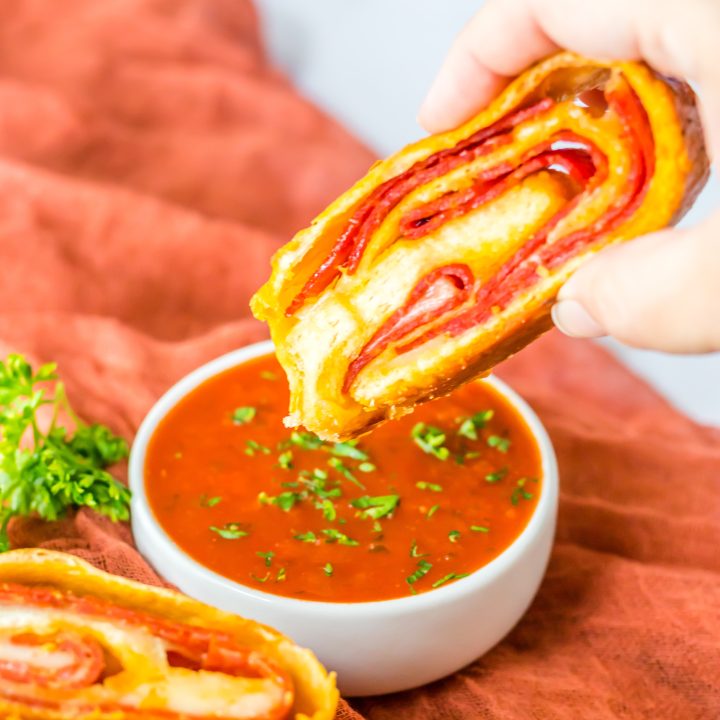 Pepperoni Bread being dipped in sauce