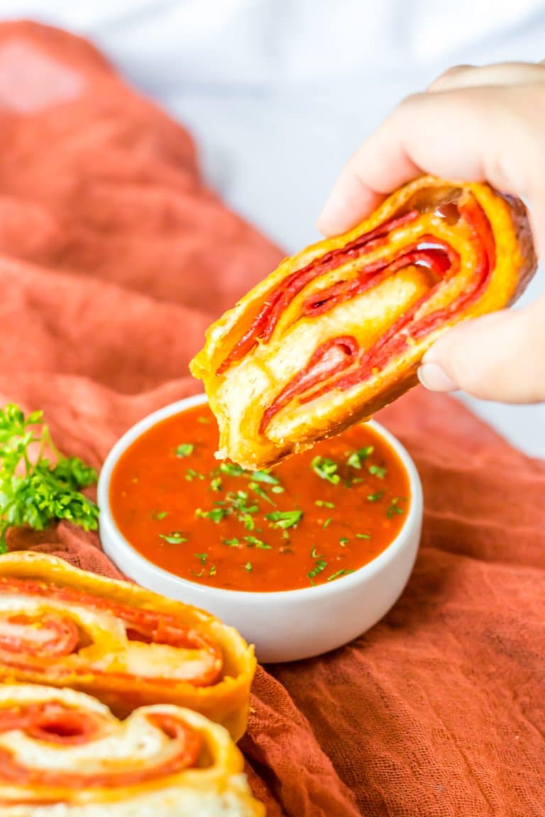 Pepperoni Bread being dipped in sauce