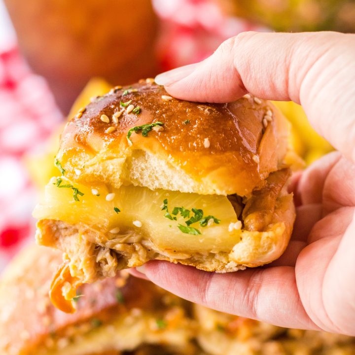 Slow Cooker Hawaiian Chicken Sliders held in hand